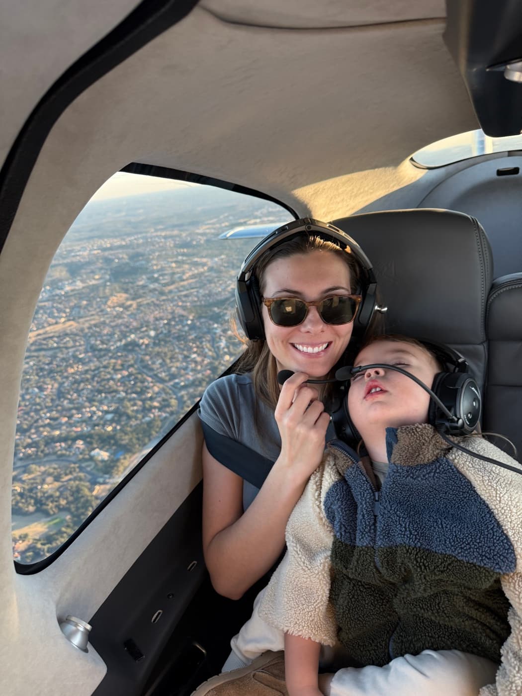 Andy's wife and sleeping toddler wearing headsets in flight