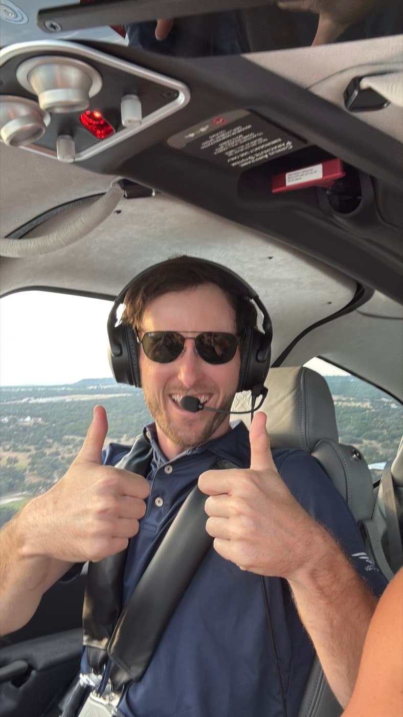 Friend in the right seat giving two thumbs up mid-flight